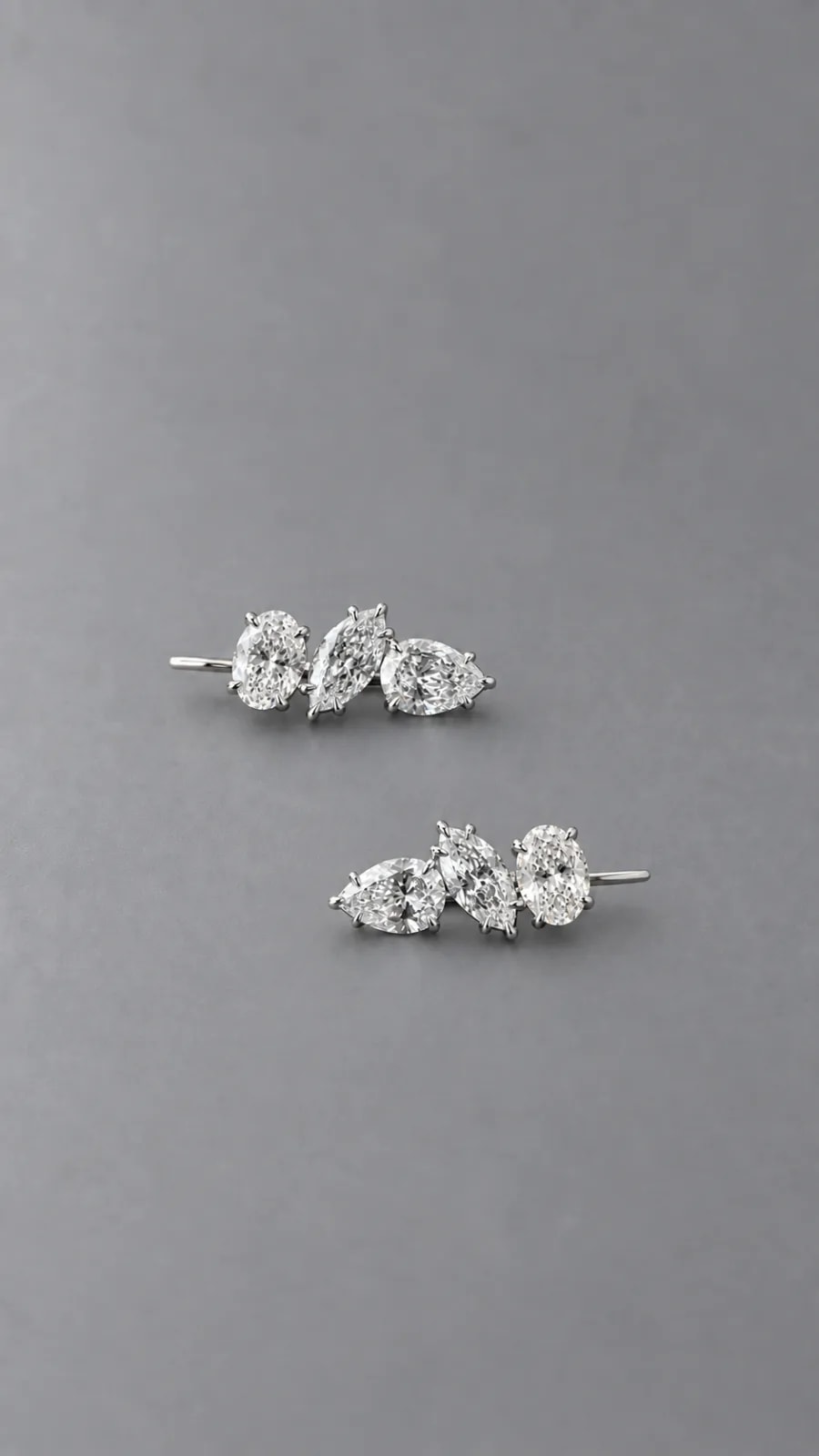 Pair of Trio Earrings — oval, marquise and pear diamonds — on a grey background
